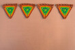 A line of four triangle crochet pieces in orange and green tones