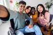© Xavier Lorenzo - Inclusion and diversity concept with young indian man in wheelchair taking selfie portrait with multiracial friends. United group of diverse young people having fun together at home