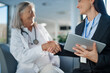 © Halfpoint - Young business woman shaking hand with elderly doctor.