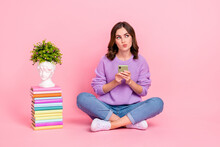 Full Length Photo Of Sweet Doubtful Lady Wear Violet Sweater Looking Empty Space Choosing Modern Gadget Book Pile Isolated Pink Color Background
