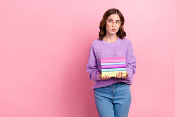 Wall Mural - Photo of unsure dreamy girl dressed purple pullover eyewear looking empty space holding book pile isolated pink color background