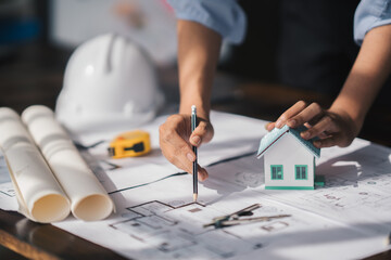 Cropped shot of Professional architect working at his desk, measuring and estimating the house project.