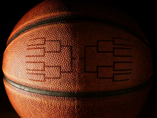 closeup of a basketball with a tournament bracket