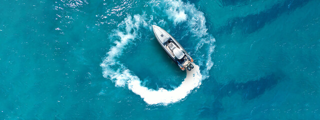 Wall Mural - Aerial drone top down ultra wide photo with copy space of inflatable power rib boat making extreme manoeuvres in Mediterranean bay with deep blue sea at dusk