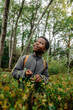 © Maskot - Smiling boy day dreaming while standing near plants in forest during vacation