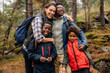 © Maskot - Happy family embracing each other while hiking in forest