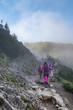 Ludzie idący szlakiem, Panorama górska, mgła otaczająca szczyty gór, droga na Kasprowy Wierch Tatry Zakopane