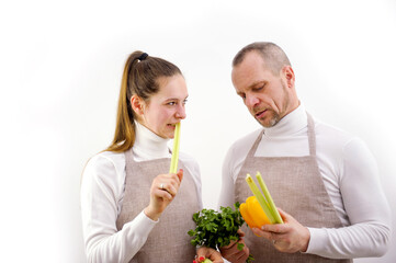 Cooking course, male chef in cook uniform teaches young female cooking class students how to cook vegetables mix food ingredients in kitchen apron two people family love vegetarianism white background