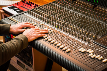 Wall Mural - male music producer, sound engineer hands on audio mixing console. music production, recording concept