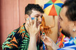 © kleberpicui - Brazilian Carnival. Reveler retouching makeup during carnival block.