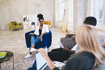 Sticker - Group of diverse designers discussing project in spacious workspace