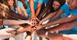 © ihorvsn - People of different ages and races are united to protect environment from pollution. Happy volunteers stacking hands together to cheer and boost team spirit. Friendship, teamwork, volunteering.