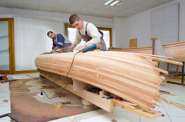 Carpenters making a wooden boat in carpenter workshop