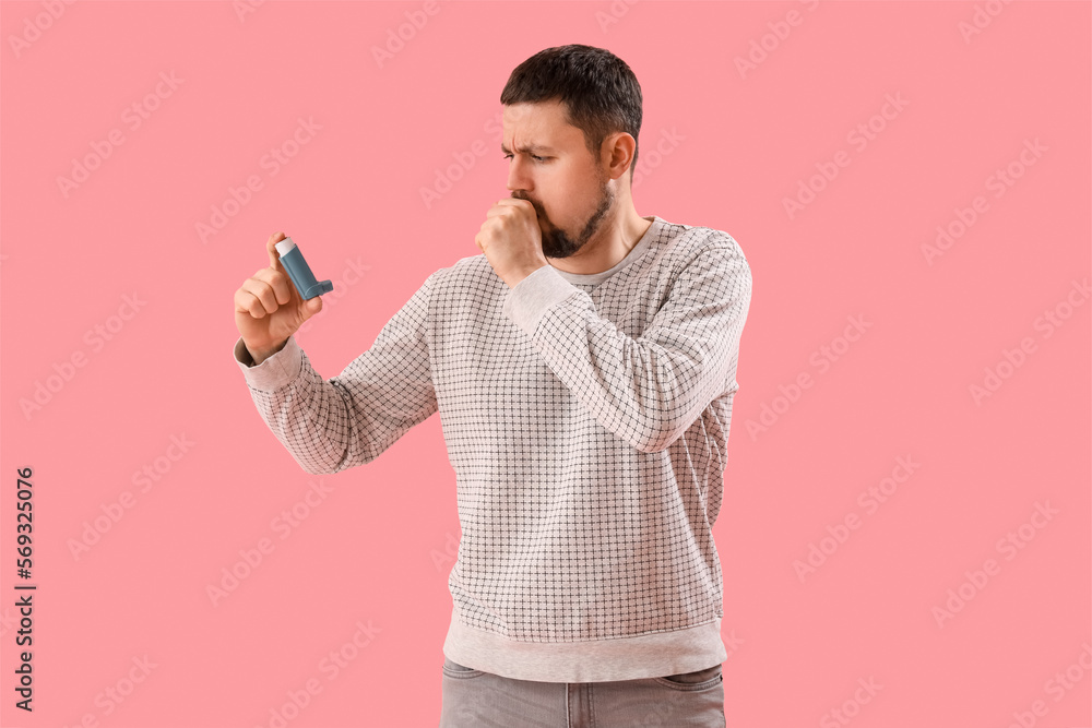 Sick man with inhaler on pink background