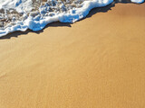 Fototapeta Kawa jest smaczna - Ocean foam covering beautiful sandy beach. Closeup.