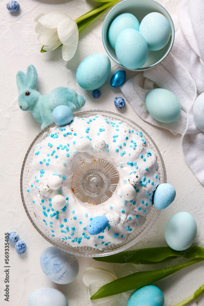 Composition with tasty Easter cake, eggs and tulip flowers on light background
