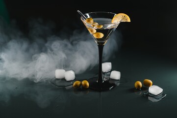 Wall Mural - Drink martini. Martini with olives on a black table. Free space for text.