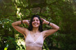 Unshaven happy young woman showing her armpit hair in the nature