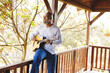 © Wavebreak Media - Bald african american senior man playing guitar and singing while sitting on railing in balcony