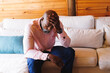 © Wavebreak Media - Stressed bald african american senior man with head in hand sitting on sofa in log cabin