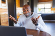 © Wavebreak Media - Happy bald african american senior man gesturing while video calling on laptop in log cabin