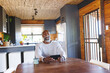 © Wavebreak Media - Bald african american senior man laughing and talking over video call on smartphone in log cabin
