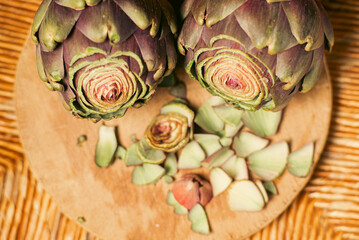 Wall Mural - Purple artichokes on a wooden background. Artichokes with the top cut off. Preparation for cooking. Vegan healthy food.