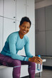 © Drazen - Happy black athletic woman at gym's locker room looking at camera.