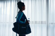 © Drazen - African American female athlete by window in dressing room at gym.