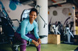 © Drazen - Happy African American athletic woman working out in gym and looking at camera.