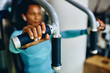 © Drazen - Close up of black sportswoman working out on exercise machine in gym.