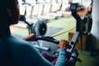 © Drazen - Close up of black sportswoman exercising on rowing machine in gym.