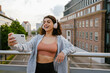 © Drobot Dean - Young woman in headphones using gadgets while working out on bridge