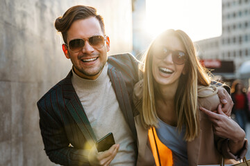 Wall Mural - happy smiling couple having fun together in city. people travel business happiness concept