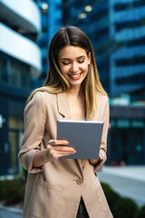 Canvas Print - Portrait of successful woman using digital tablet in urban background. Business people concept