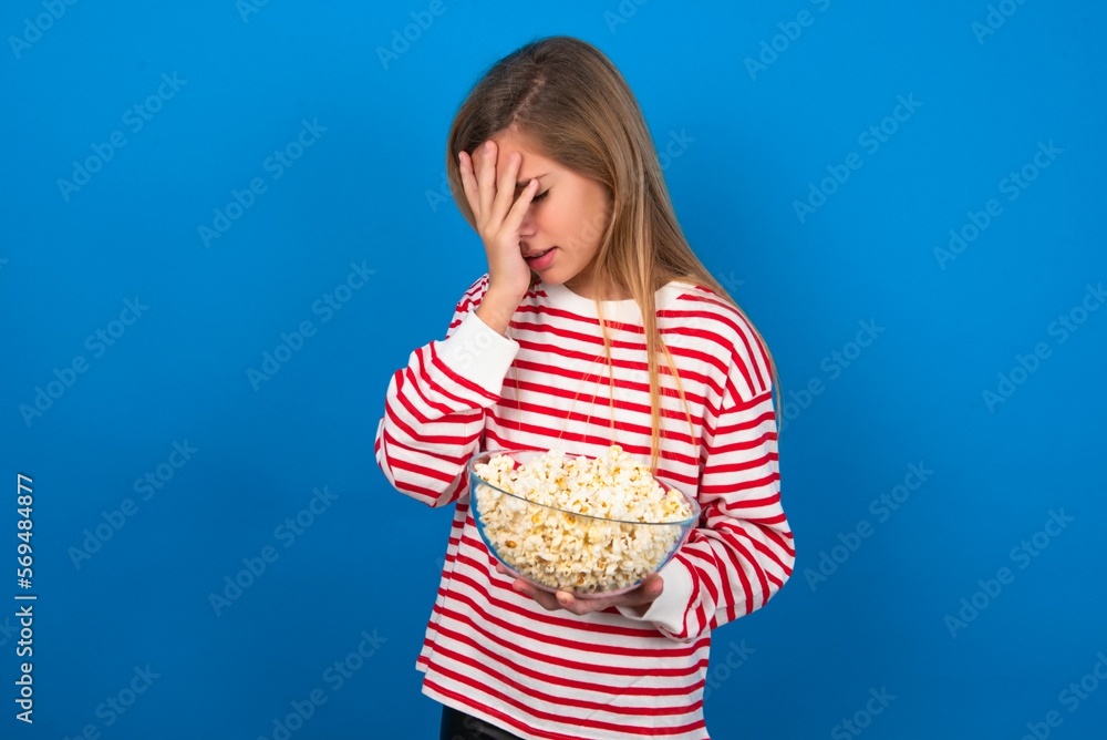 Sad beautiful caucasian teen girl wearing striped T-shirt over blue ...