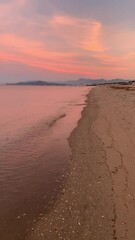 Wall Mural - Vertical panning shot of calm sea at sunset