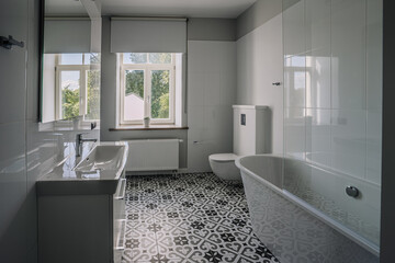 Interior of white bathroom with bathtub and toiletries