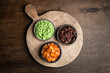 Set of indian chutneys in bowls on wooden background, top view