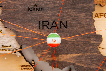 Wall Mural - Iran flag on the pushpin and red threads on the wooden map. Travel or logistic routes. Influence in geopolitics and world economy. 