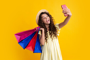 Wall Mural - Shopping bags and mobile phone in the kids hands. Teen girl after shopping. Purchases, black friday, discounts and sale concept. Summer shopping sale.