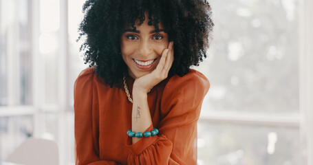 Canvas Print - Face, vision and mindset with a business black woman sitting at a desk with her hand on her chin. Portrait, happy and smile with a female employee thinking about future growth or company development