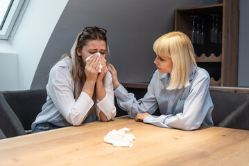 Young friend woman comforting her sad depressed colleague in office who crying after mistake at work on new company project and is under stress and fear of job lost