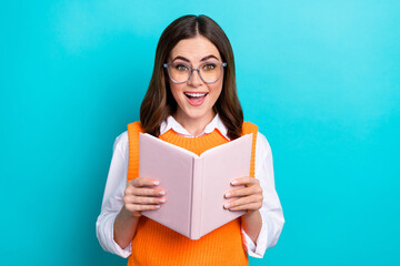 Poster - Photo of positive impressed cheerful woman with bob hairstyle orange waistcoat hold interesting book isolated on teal color background