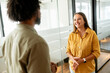 © Vadim Pastuh - Two colleagues have pleasant conversation standing in the walkhall of the modern open space office, smiling and enjoying friendly working atmosphere, smiling woman listening her male coworker
