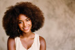 © Nedrofly - Beauty portrait of African American woman with clean healthy skin on beige background. Smiling dreamy beautiful black woman. Curly hair in afro style