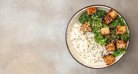 Wall Mural - Savory sauteed mixed chinese rice, broccoli with fried tofu, Asian vegan bowl, Long banner format. top view