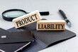 PRODUCT LIABILITY text on wooden block on black notebook , business concept
