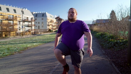 One overweight young man moving body before exercise. Plus size male caucasian person preparing for running outdoors