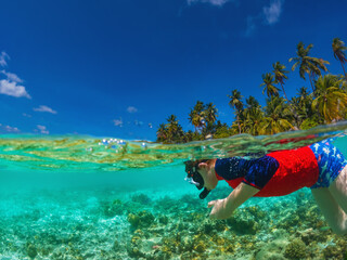  Beautiful maldives tropical island - a boy snorkels underwater.